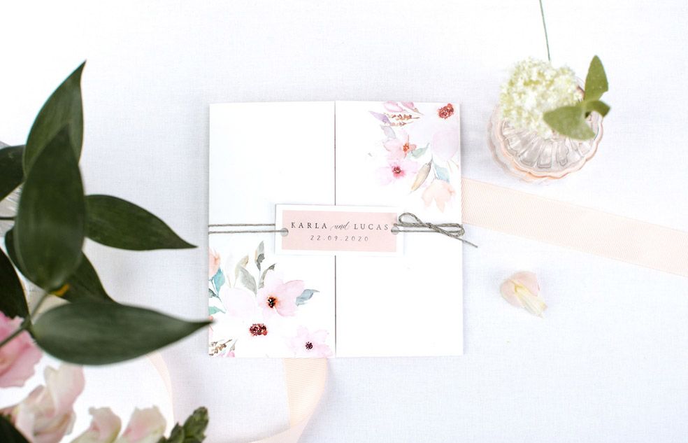 Florale Hochzeitseinladung als Altarfalz mit Anhänger und rosa Blueten der Serie Karla und Lucas von carinokarten